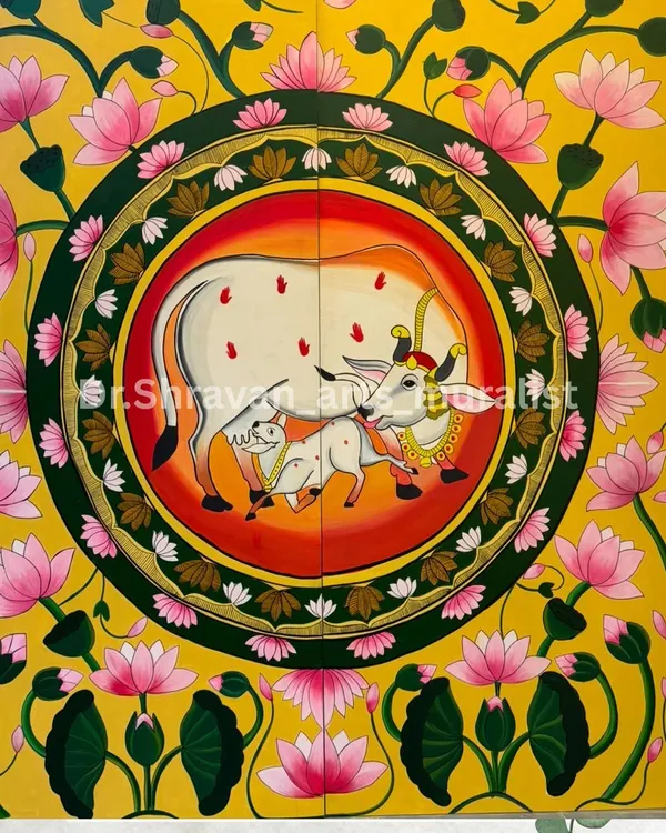 A classic Pichwai painting featuring the sacred cow and calf, surrounded by a circle of lotuses. The vibrant yellow background and intricate details bring a sense of divinity and tradition to the space.