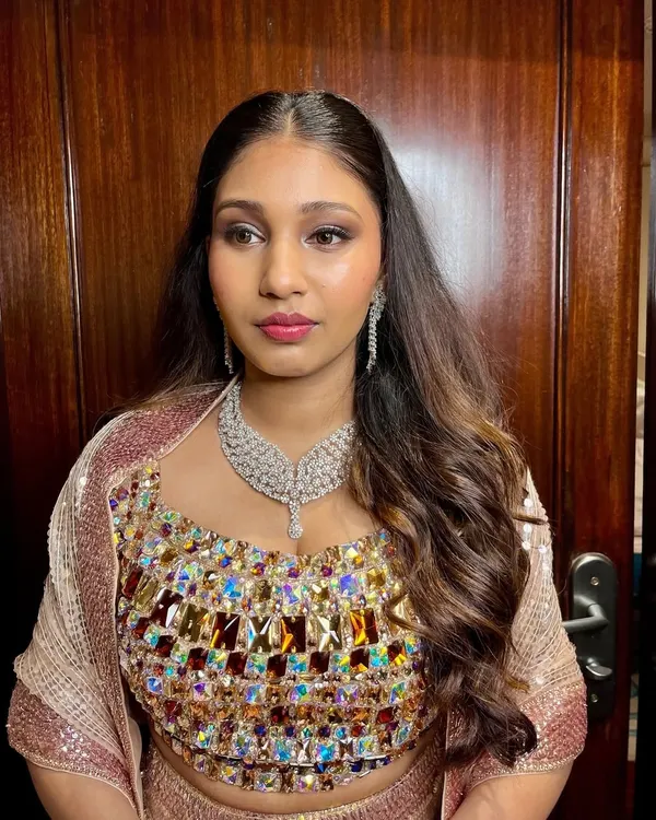 Reception nights call for glam that turns heads. This look features soft shimmer on the eyes, a glassy skin glow, and sleek waves for a truly stunning effect.