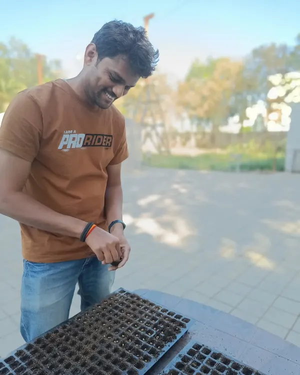 It all begins here. My engineer Sumanth is helping sow seeds for the next cycle. This careful, hands-on work ensures we start with strong, viable plants for your farm.