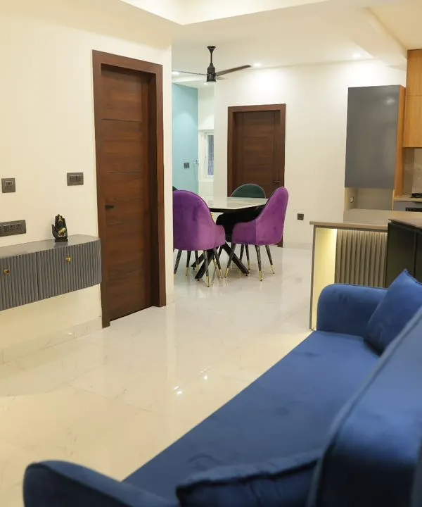 This view shows how the living and dining areas connect in an open-plan layout. The vibrant purple chairs add a pop of color, while the floating console keeps the entryway feeling spacious.