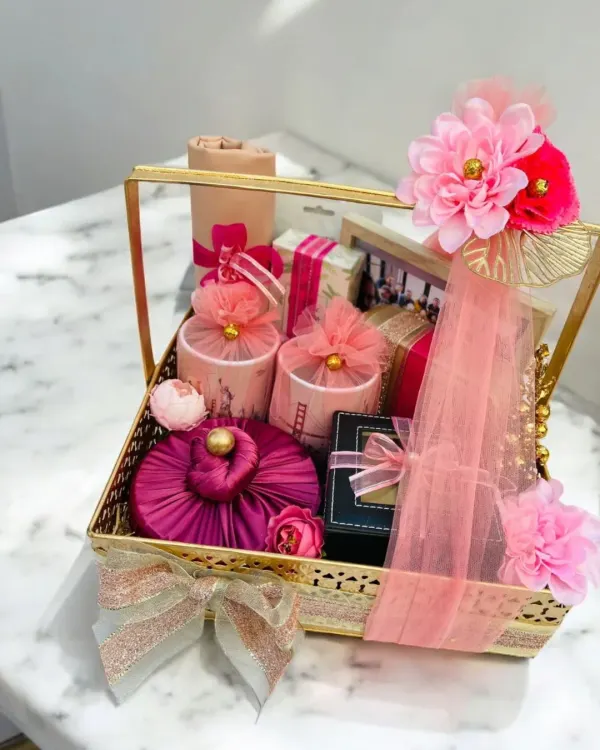 A beautifully curated engagement hamper, blending vibrant pinks and elegant gold. This basket is filled with thoughtfully selected gifts, each wrapped and arranged to celebrate the beginning of a new journey.
