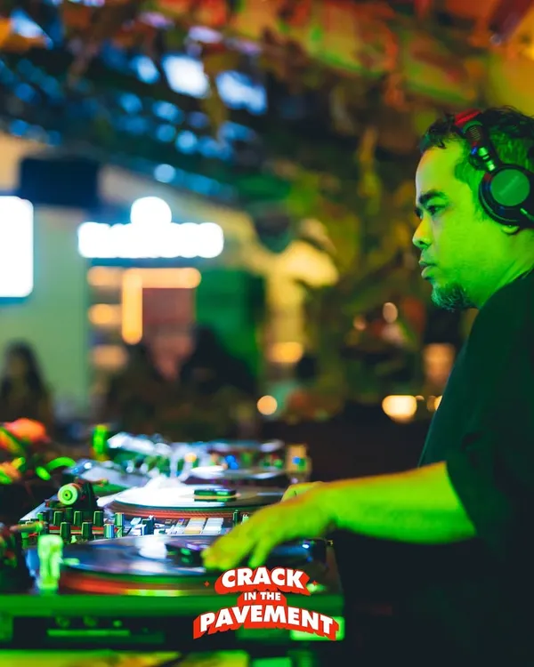 Locked in during a set. The green light, the focus, the crowd in the background, this is the essence of a live performance.