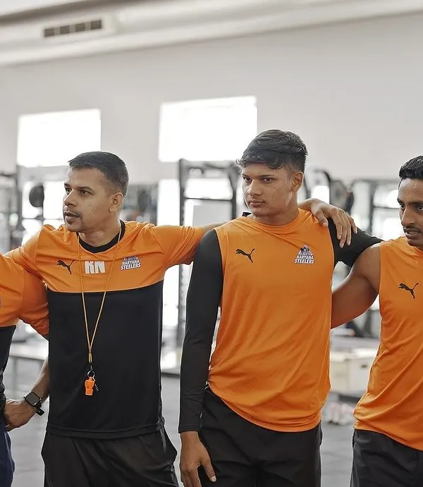 Prep on point. A moment with the coaching staff and players, discussing the plan for the session. Alignment and communication are crucial.