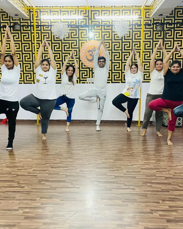 This is what our community is all about. We welcome everyone, regardless of age or fitness level, to join us on the mat. Here, we are practicing Vrikshasana, or the tree pose, together to improve our balance and focus.