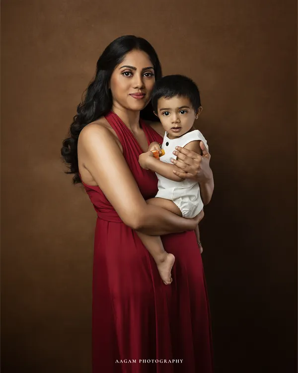 A mother's love, captured in a timeless frame. This classic portrait against a painterly brown backdrop has the feel of an old master's painting, elegant and everlasting.