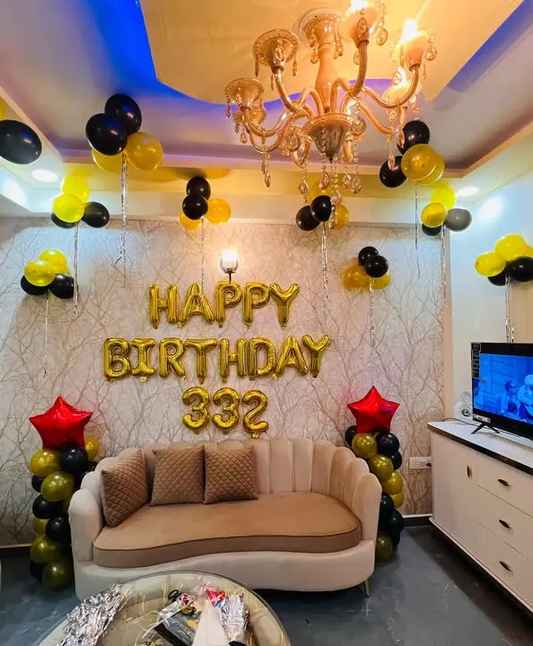 A simple yet festive birthday decoration for a living room. I used gold foil "Happy Birthday" balloons as the main feature, with black and yellow balloon clusters to fill the space.
