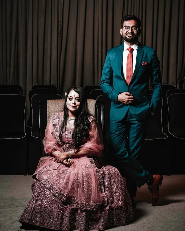 A classic and elegant portrait from an engagement ceremony. The couple poses with poise and confidence, showcasing their stylish formal wear and the celebratory atmosphere of the event.