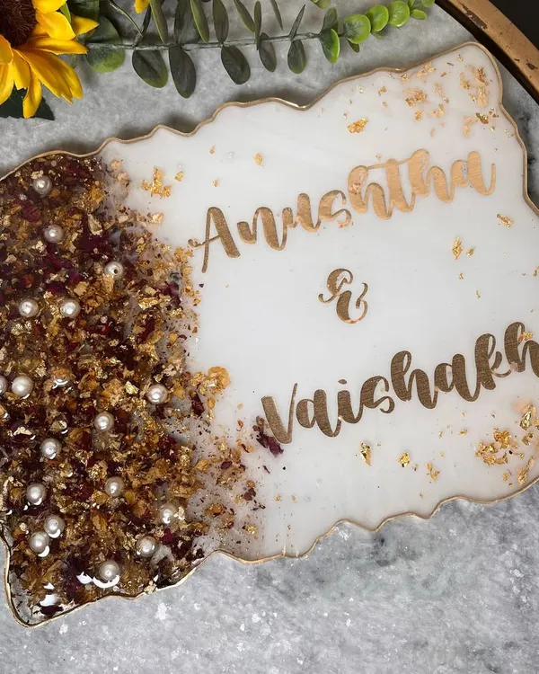 A simple and elegant nameplate made with a couple's preserved wedding garland. The white resin and gold lettering create a classic look for their home.