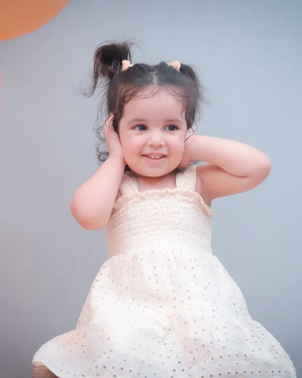 Officially two and still stealing hearts! This little girl's personality shines in her second birthday portrait, complete with a cute dress and pigtails.