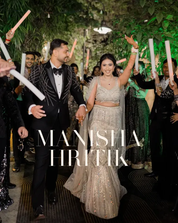 A grand entrance for a grand night. The couple walks in, hand in hand, through a tunnel of light sticks held by their cheering friends and family.