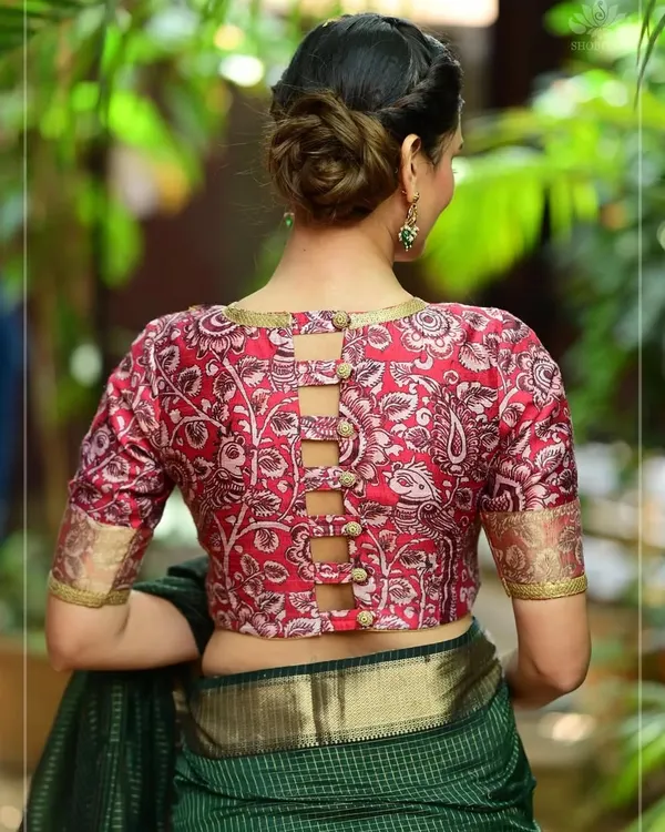 This red printed blouse features a unique buttoned-up ladder design on the back, offering a modern twist on a traditional pattern.