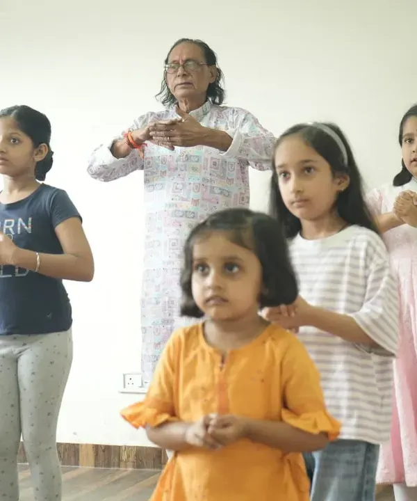 A beautiful moment capturing the Guru-Shishya parampara. An experienced guru patiently teaches the fundamentals of classical dance to a group of young, attentive students.
