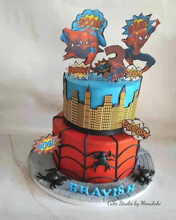 A dynamic two-tier Spiderman cake for a young fan. The bottom tier features the classic web design, while the top shows a city skyline, all brought to life with fun comic book-style toppers.