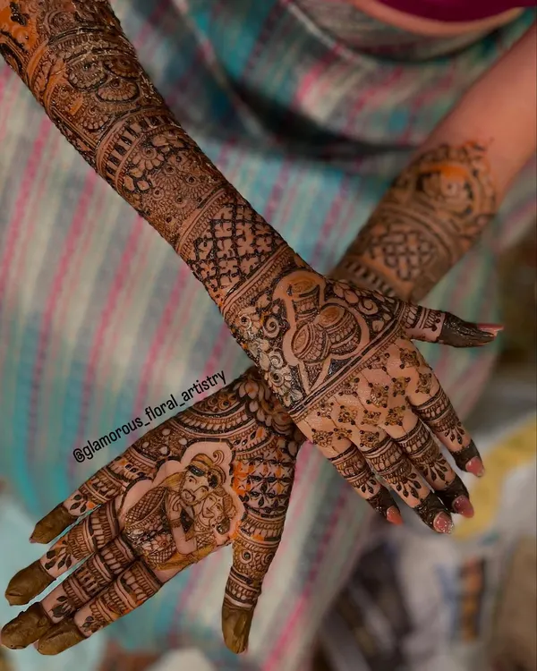 A complete view of bride Namratha's stunning bridal mehendi, featuring a couple portrait on one palm and a traditional kalash on the other, surrounded by intricate patterns.