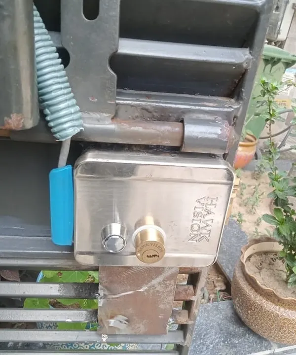 This is a Hawkvision electronic door lock I installed on a metal gate in Noida. It's a robust lock that can be operated with a key or electronically, providing dual security.