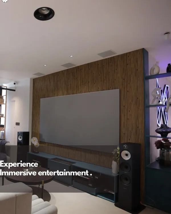 We believe world-class entertainment should blend perfectly with your home's design. This living room setup features a large format screen and high-fidelity tower speakers, creating a powerful media experience that complements the modern interior.