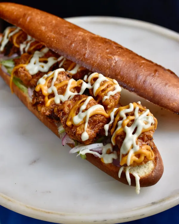 Our Hot Honey Fried Chicken Sandwich is a weekend special that always sells out. It's packed with crispy fried chicken, a spicy habanero hot sauce, and a cooling house-made blue cheese sauce on a soft brioche bun.