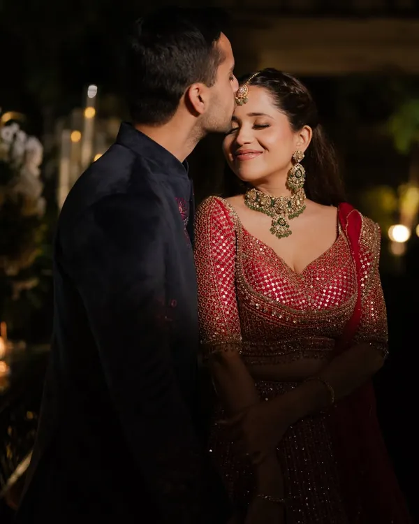 A romantic moment from Janhvi’s cocktail night. Her makeup features a warm, smokey eye and a glowing base that looks incredible in the low light, complementing her red Seema Gujral lehenga.