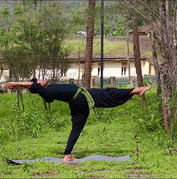 Practicing Hurdhvamuka Veerabhadrasana in a quiet green space. Each yoga posture offers a different perspective on life, helping us to understand situations with more clarity and handle them with balance.