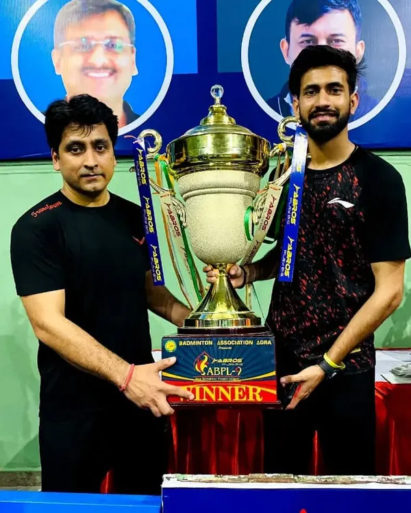 Our Head Coach, Ravindra Singh, holding the winner's trophy for the Agra Badminton Premier League. This victory demonstrates the high caliber of our coaching leadership.