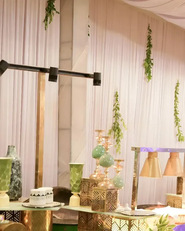 A stylish decor arrangement featuring modern metallic vases, candle holders, and track lighting. We use these elements to create a sophisticated and contemporary atmosphere.