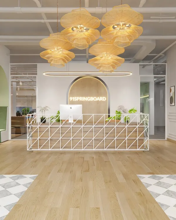 A rendering of the main reception desk for the coworking space, featuring a geometric white metal base and a warm wood top. The statement pendant lights and neon signage create a bold and welcoming entry point.