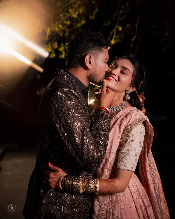 A stolen, playful moment during their Sangeet night. The dramatic lighting and his affectionate gesture make this a memorable and heartwarming candid shot.