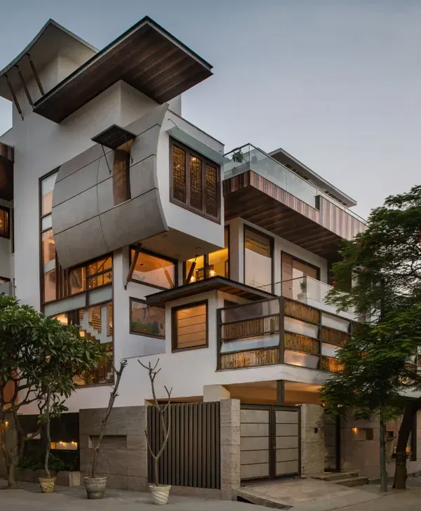 This dusk view of the Ashraya Residence captures the dynamic interplay of cantilevered forms, warm lighting, and natural materials. My design philosophy is embodied here, creating a modern structure that feels both monumental and intimately connected to its surroundings.