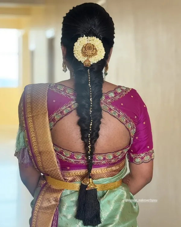 A traditional South Indian bridal braid is a work of art. This classic fishtail braid, adorned with jasmine flowers and a statement gold jada, is a timeless choice for a muhurtham ceremony.