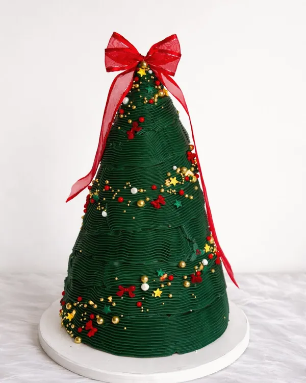 If Christmas was a cake, this would be it! I had so much fun creating this tiered Christmas tree cake, complete with edible ornaments and a big red bow. It’s a true centerpiece for any holiday party.