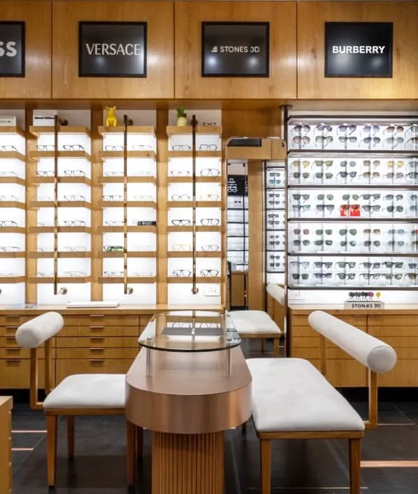 A view of the EYE 2 EYE LUXE eyewear store, where I designed custom furniture and display units. The space uses mirrors to create an illusion of depth, reflecting the warm wood and elegant seating.