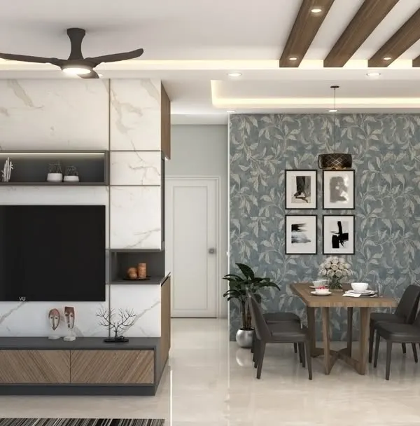 An integrated living and dining space where a marble-finish TV unit complements the subtle wallpaper and wooden ceiling rafters. This design creates a cohesive and modern look for the entire area.