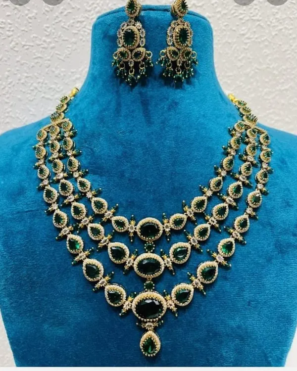 A Victorian-style three-layer necklace with matching earrings. The set features large emerald-green stones, perfect for adding a pop of color to your reception outfit.