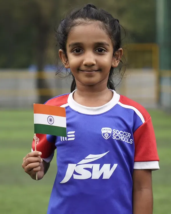 A young girl from our soccer school holds the Indian flag with pride. We are dedicated to nurturing the next generation of female athletes for our country.