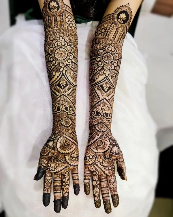 A mega bridal henna design for Saleha, covering the arms almost to the elbow. This style is incredibly detailed, with repeating mandalas, geometric grids, and floral patterns for a truly grand look.