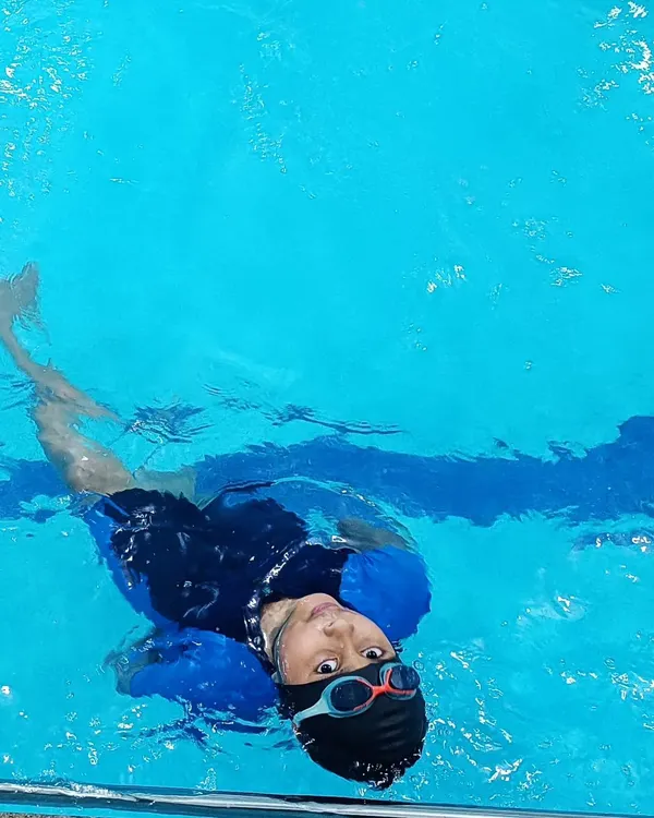 A young swimmer learning to float on his back, a key step in building water confidence in our beginner swimming lessons.