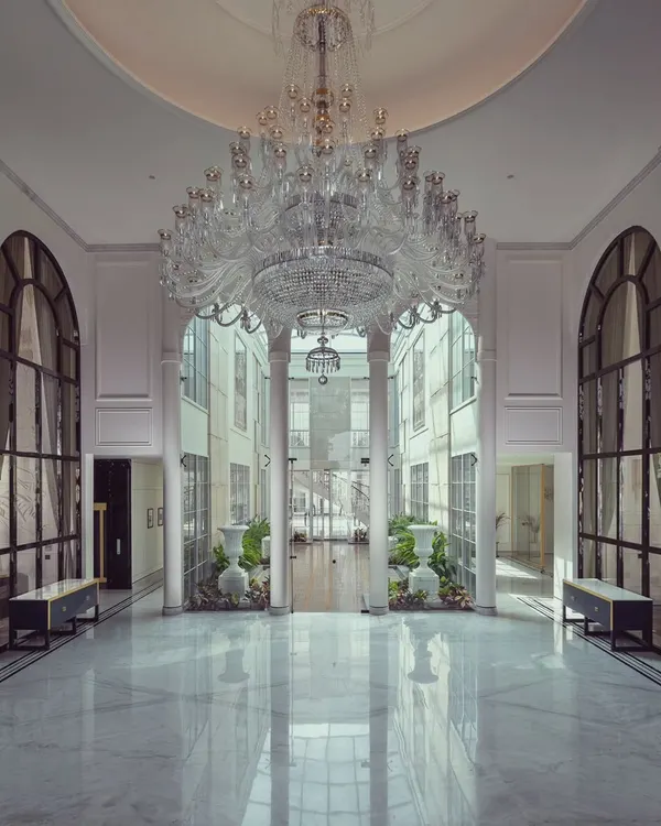 This grand hotel atrium, featured in a leading design magazine, exemplifies our approach to creating monumental hospitality spaces. The soaring, multi-story hall is crowned by a massive crystal chandelier, with polished marble floors reflecting the light and creating an awe-inspiring sense of arrival.