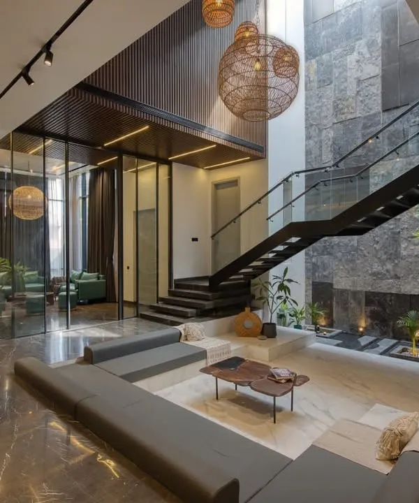 This double-height living area, featuring a sunken lounge and a dramatic stone-clad wall, is the heart of the home. We designed this space to feel both grand and intimate, balancing expansive volume with warm, natural materials and carefully considered lighting.