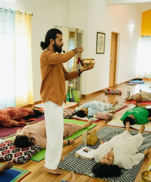 During a sound healing teacher training course, I guide participants into a state of deep rest, known as Yoga Nidra. Here, I am using a Tibetan singing bowl to create gentle vibrations that calm the nervous system.