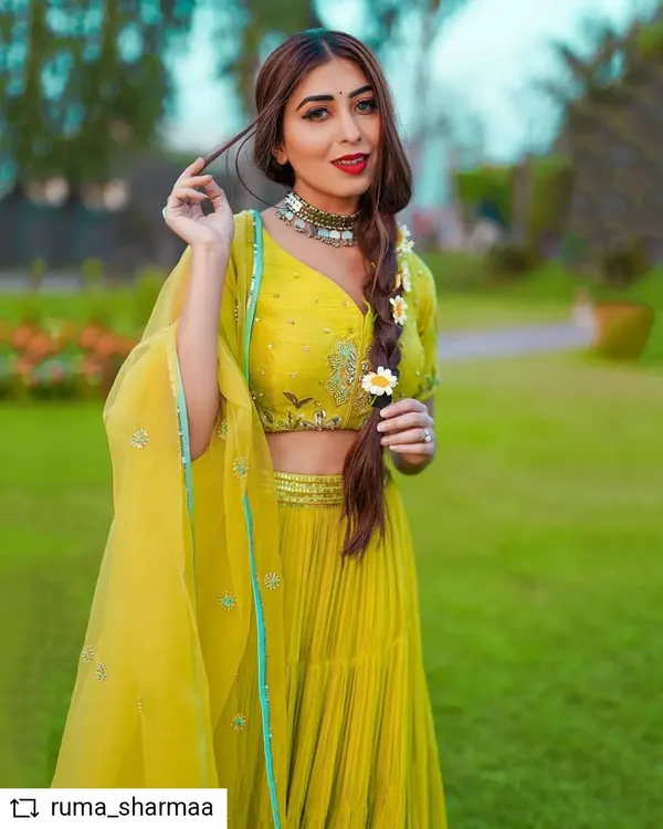 This is a custom-styled look featuring my lime-green pleated lehenga. I paired it with an embroidered blouse and a sheer dupatta for a festive look. The styling, including the braided hair with flowers, brings a fresh and youthful energy to the outfit.