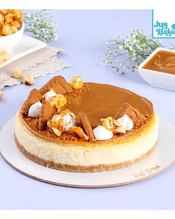 A full view of my Biscoff Baked Cheesecake, one of our bestsellers. The top is covered in smooth Biscoff spread, crushed biscuits, and delicate meringue kisses for that perfect finish.