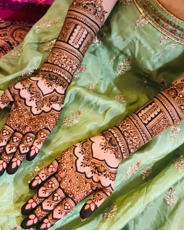 This is a classic full bridal mehendi with extremely fine and intricate details. The patterns include delicate paisleys, florals, and geometric fills, creating a rich and luxurious look.