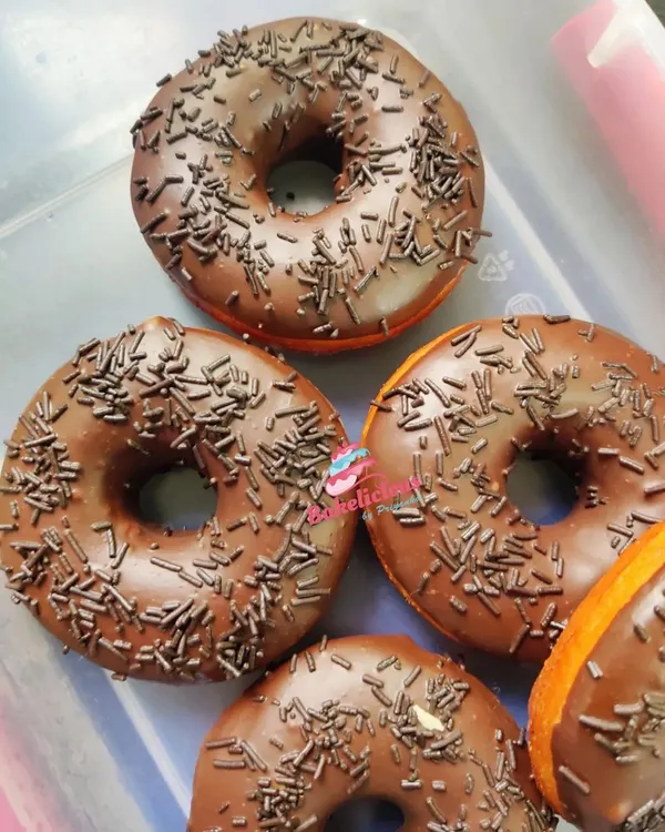 A fresh batch of my soft, fluffy doughnuts, ready for delivery. Each one is 100% eggless, dipped in a rich chocolate glaze, and finished with chocolate sprinkles. I bake these only after you order, so you always get the freshest possible treat for your snack time.