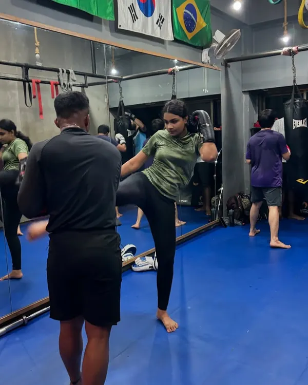 Our women's kickboxing classes are designed to build strength, speed, and precision. This student is perfecting her form during a pad work drill.