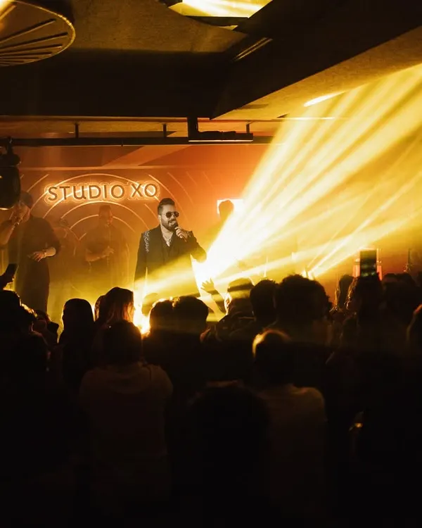 A wide shot of Mika Singh performing at Studio XO, capturing the impressive stage lighting and the large, engaged audience. This shows our ability to capture the entire event atmosphere.