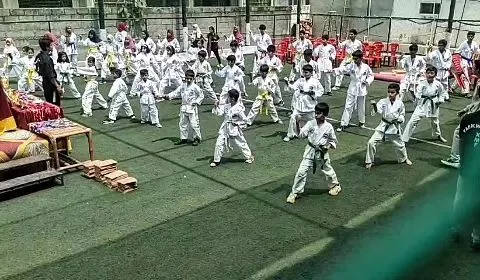 A snapshot of our large group training session on an outdoor turf. Students are practicing their basic stances and blocks in unison, building a strong foundation in Taekwondo discipline and form.