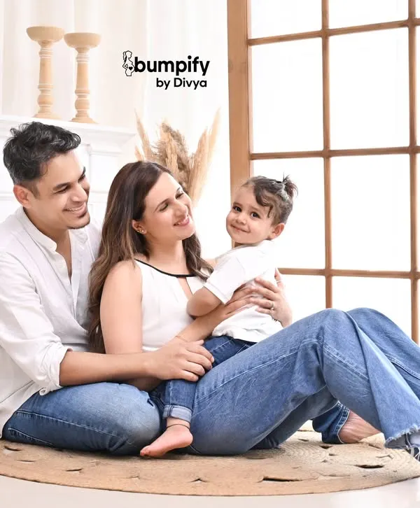 A relaxed and happy family portrait in our bright, airy studio. The simple, modern setup with a fireplace and pampas grass allows the family's connection to be the main focus.