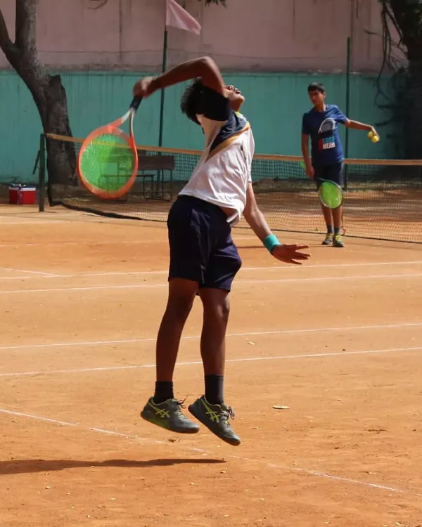 This is what the grind looks like. A junior player showing explosive power in his serve during a tense semi-final match. We create an environment where every player can push their limits.