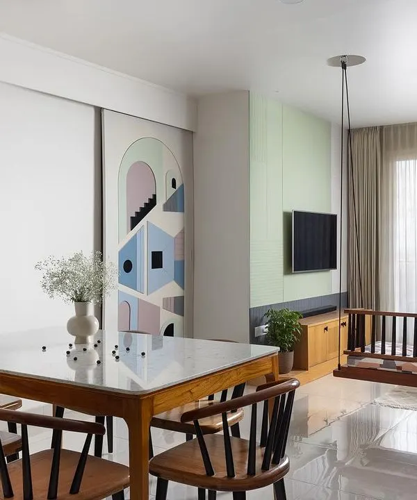 This living area from 'The Pastel Abode' project showcases a gentle color palette of mint green, blush pink, and pastel blue. The artful sliding door, when open, reveals the bedroom corridor and acts as a unique design feature.