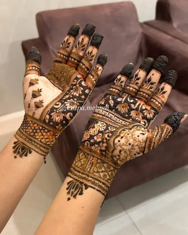 This is a perfect example of a full-hand design for the festive season. It combines dense floral patterns with geometric wristbands and delicate dot work, creating a rich and celebratory look.